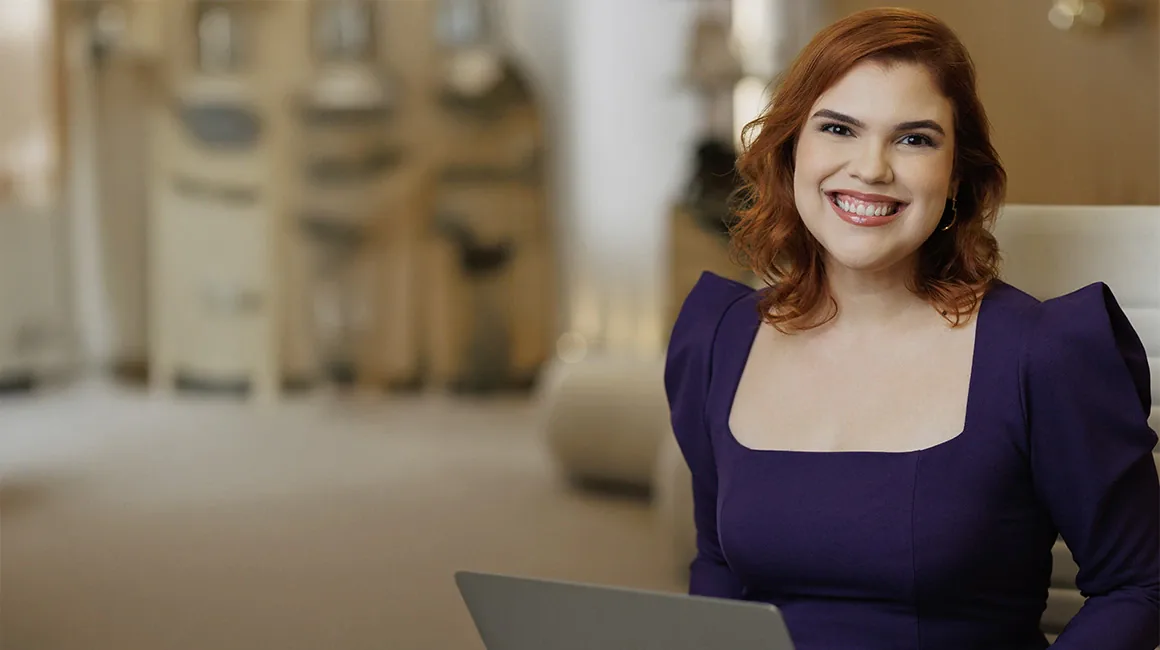 Dra. Mariana Barbalho no consultório, sorrindo com vestido roxo